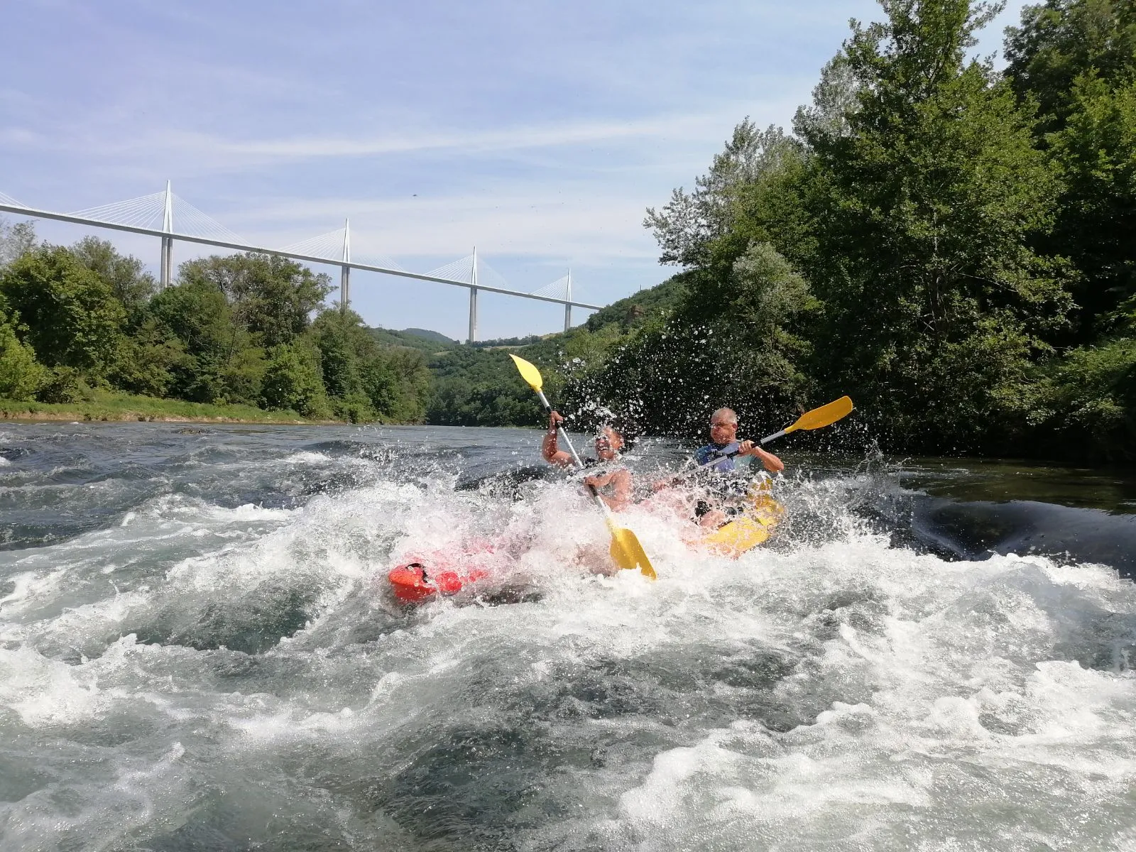 Deux kayakistes dans un rapide, le viaduc en arrière-plan